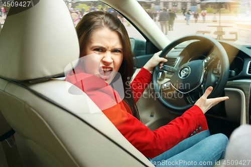 Image of Driving around city. Young attractive woman driving a car