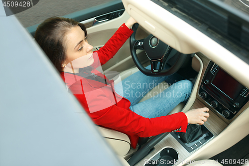 Image of Driving around city. Young attractive woman driving a car