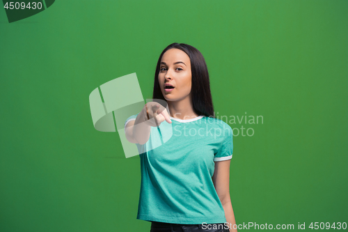 Image of The happy business woman point you and want you, half length closeup portrait on green background.