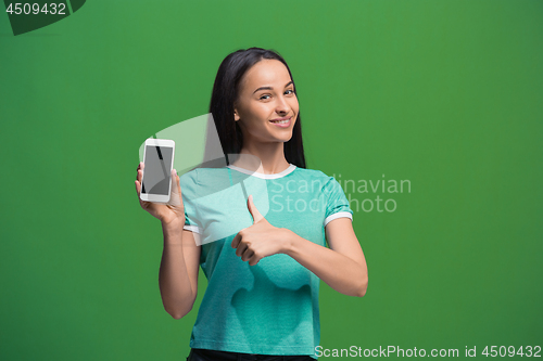 Image of Portrait of a smiling woman showing blank smartphone screen