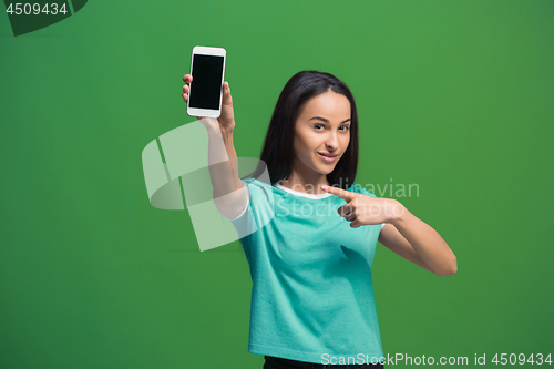 Image of Portrait of a smiling woman showing blank smartphone screen