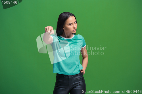 Image of The overbearing business woman point you and want you, half length closeup portrait on green background.