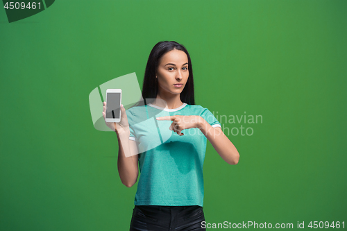 Image of Portrait of a smiling woman showing blank smartphone screen