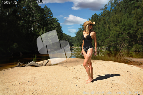 Image of Aussie woman in bikini  in bushland river bank