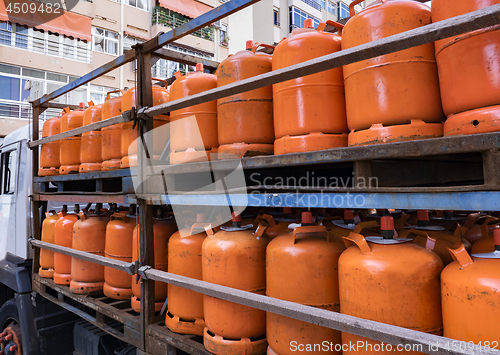 Image of Truck full of orange gas cylinders transporting butane