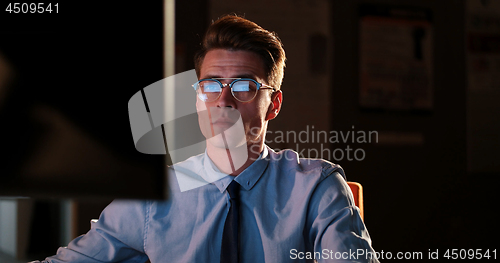 Image of man working on computer in dark office