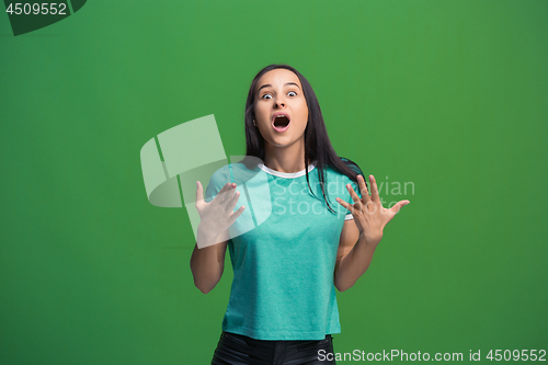 Image of Beautiful woman looking suprised isolated on green