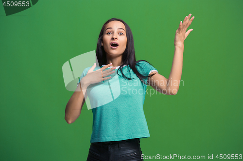 Image of Beautiful woman looking suprised isolated on green