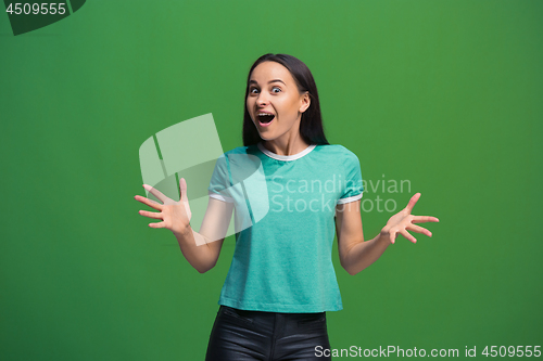 Image of The happy business woman standing and smiling against green background.