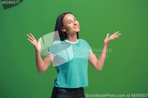 Image of The happy business woman standing and smiling against green background.