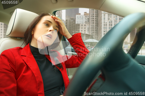 Image of Driving around city. Young attractive woman driving a car