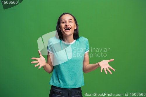 Image of The happy business woman standing and smiling against green background.