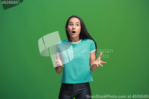 Image of Beautiful woman looking suprised isolated on green