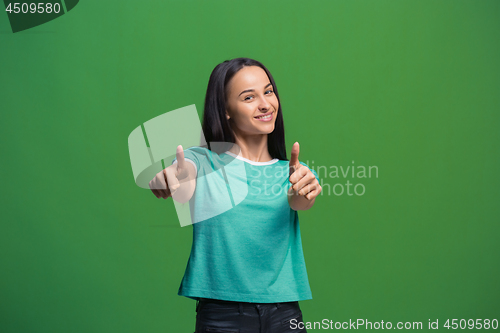 Image of The happy business woman standing and smiling against green background.