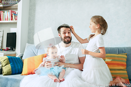 Image of The happy father and his baby daughters at home