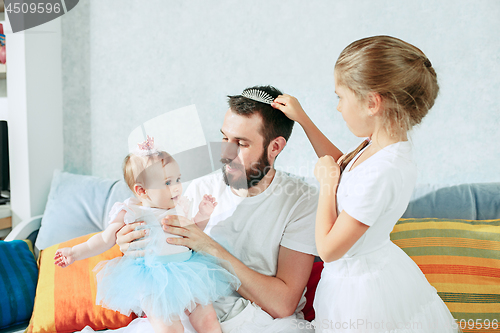 Image of The happy father and his baby daughters at home