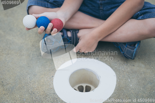 Image of Happy little boy playing mini golf playing mini golf