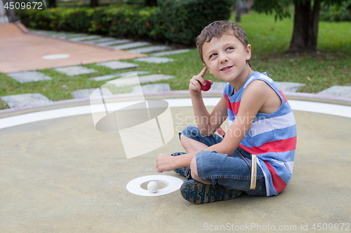 Image of Happy little boy playing mini golf playing mini golf