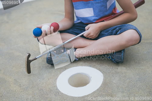 Image of Happy little boy playing mini golf playing mini golf