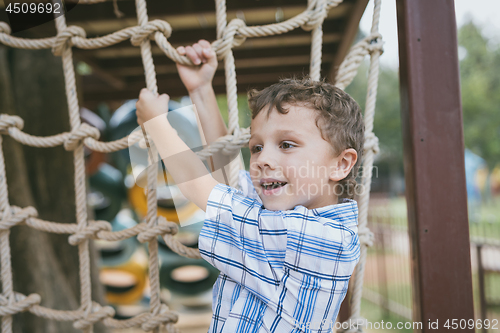 Image of little boy make climbing in the adventure park.