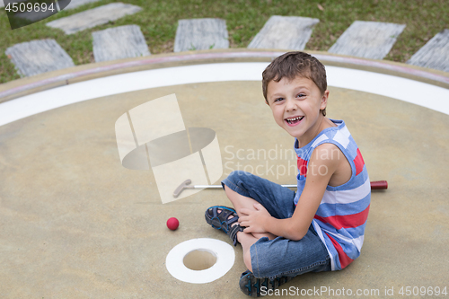 Image of Happy little boy playing mini golf playing mini golf