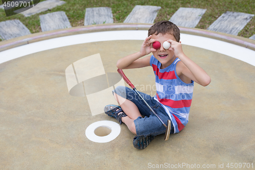 Image of Happy little boy playing mini golf playing mini golf