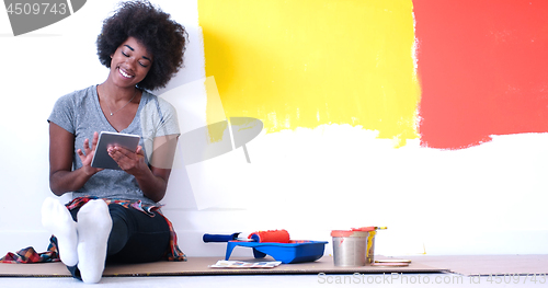 Image of black female painter sitting on floor