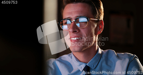 Image of man working on computer in dark office