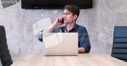 Image of businessman working using a laptop in startup office