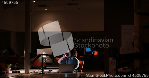 Image of man working on computer in dark office