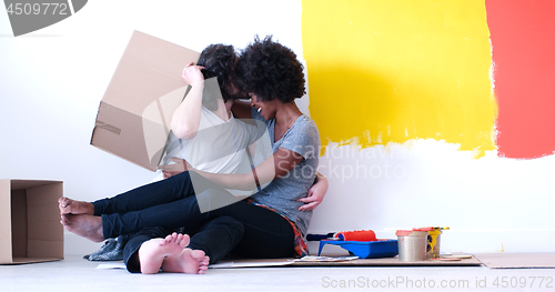 Image of young multiethnic couple playing with cardboard boxes