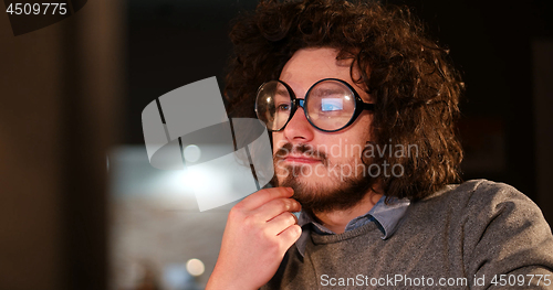 Image of man working on computer in dark office