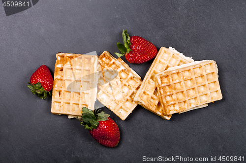 Image of Belgium waffers and strawberries on black board background. 