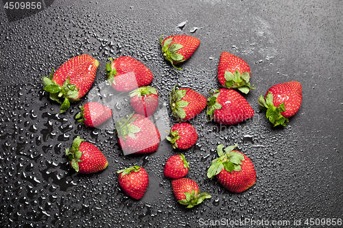 Image of Fresh ripe strawberry with water drops on black background.