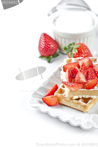 Image of Belgium waffers with sugar powder and strawberries on ceramic pl