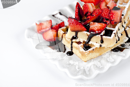 Image of Belgium waffers with sugar powder, strawberries and chocolate on