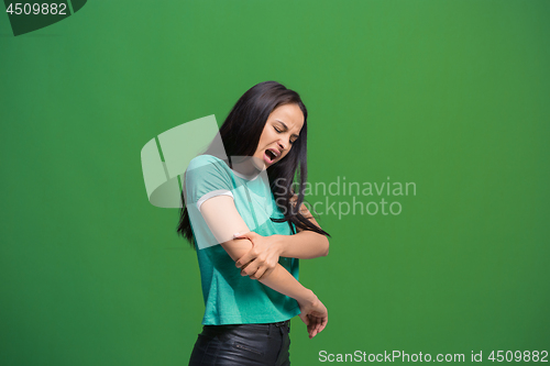 Image of Young woman overwhelmed with a pain in the elbow