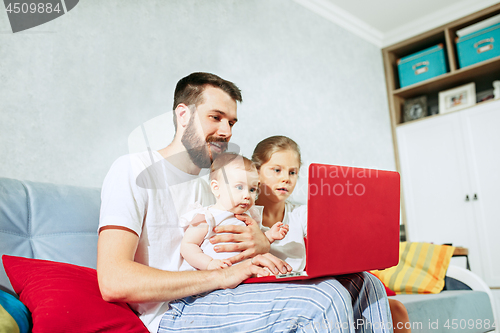 Image of father and his daughters at home