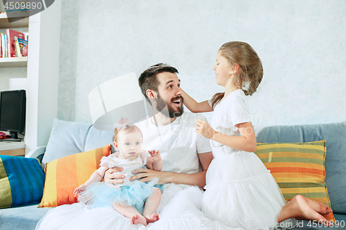 Image of The happy father and his baby daughters at home