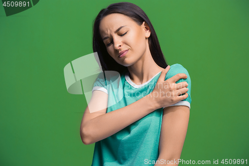 Image of Young woman overwhelmed with a pain in the shoulder