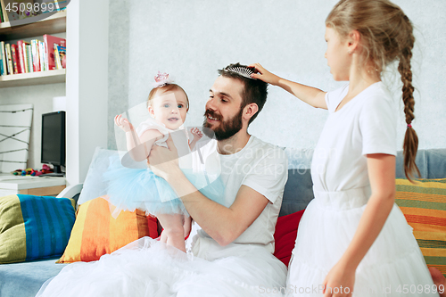 Image of The happy father and his baby daughters at home