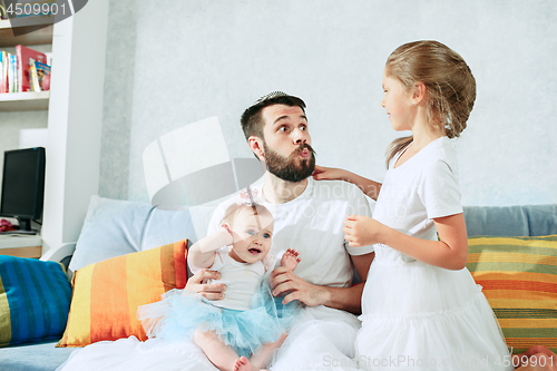 Image of The happy father and his baby daughters at home