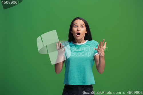 Image of Beautiful woman looking suprised isolated on green