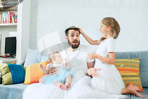 Image of The happy father and his baby daughters at home