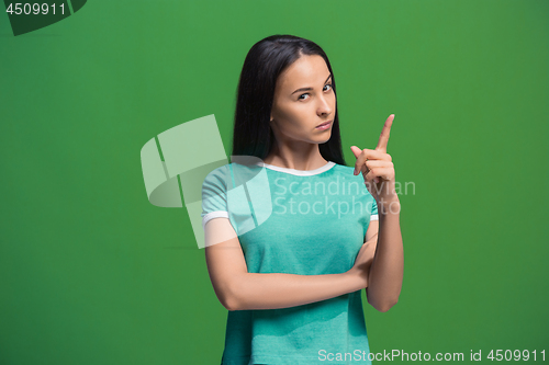 Image of Let me think. Doubtful pensive woman with thoughtful expression making choice against grreen background
