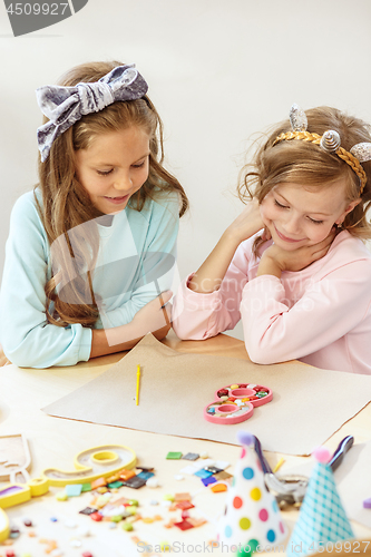 Image of Girl birthday decorations. table setting with cakes, drinks and party gadgets.