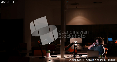 Image of man working on computer in dark office