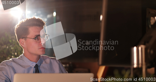 Image of man working on computer in dark office