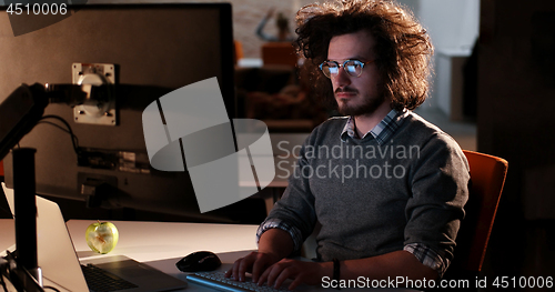 Image of man working on computer in dark office