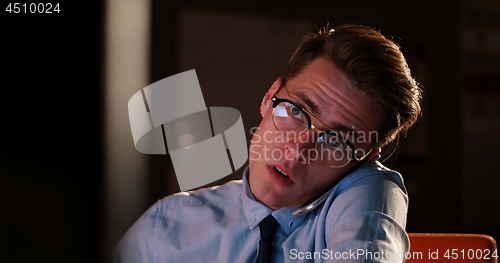 Image of man using mobile phone in dark office